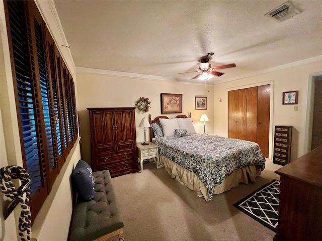 bedroom with carpet flooring, a textured ceiling, ceiling fan, and crown molding