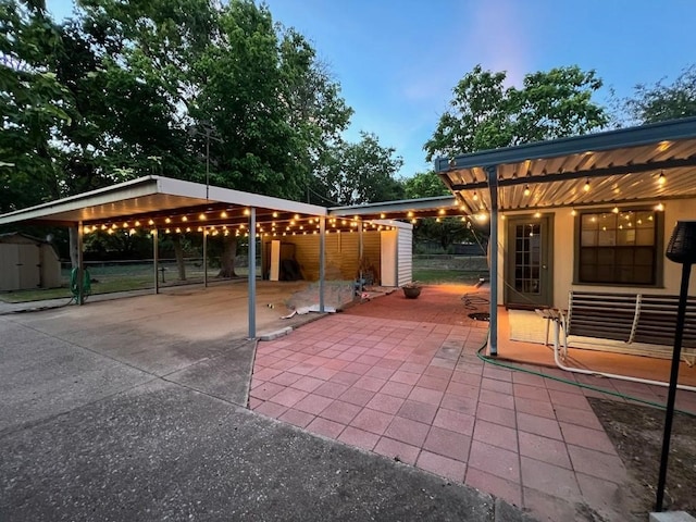 patio terrace at dusk featuring a shed