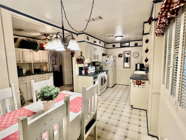 kitchen with white appliances, a notable chandelier, decorative light fixtures, and sink