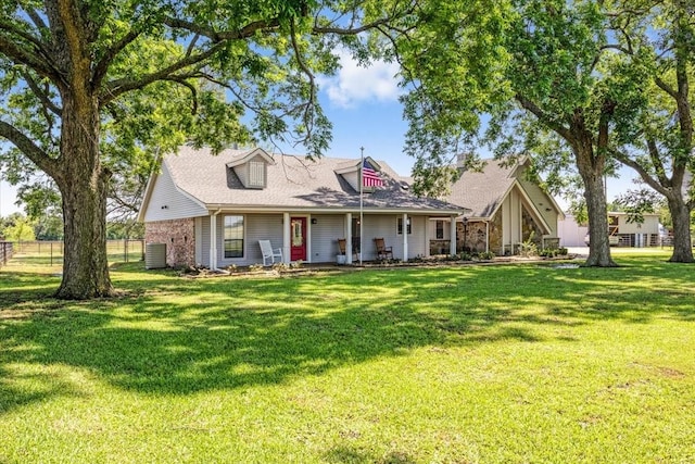 view of front of house with central AC and a front yard