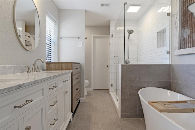 full bathroom featuring toilet, plus walk in shower, tile walls, tile patterned floors, and vanity