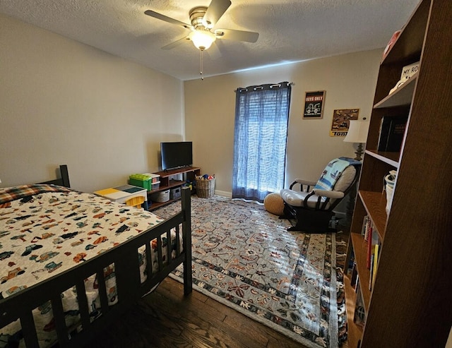 bedroom with ceiling fan, a textured ceiling, and dark hardwood / wood-style flooring