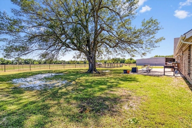 view of yard with a rural view and a patio area