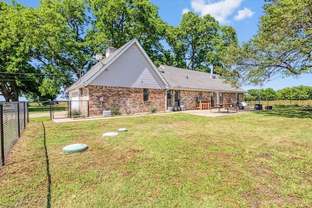 back of house featuring a patio area and a lawn