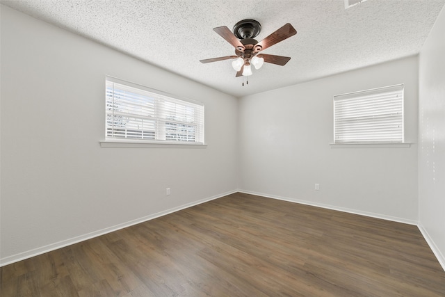 empty room with a textured ceiling, ceiling fan, and dark hardwood / wood-style floors