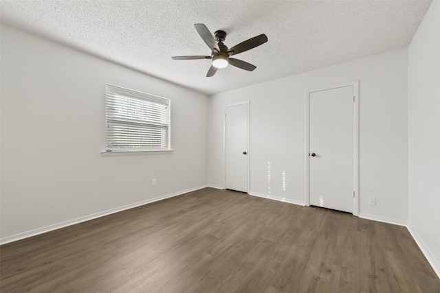 unfurnished bedroom with a textured ceiling, ceiling fan, and dark hardwood / wood-style floors