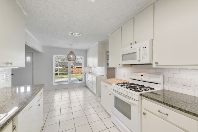 kitchen featuring decorative light fixtures, backsplash, white appliances, white cabinetry, and dark stone counters