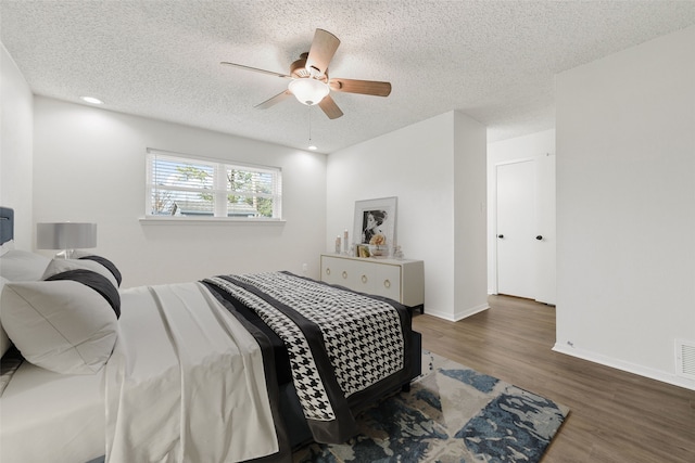 bedroom featuring ceiling fan, dark wood-type flooring, and a textured ceiling