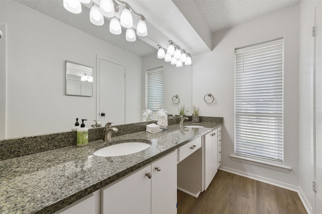 bathroom featuring a textured ceiling, hardwood / wood-style flooring, and vanity