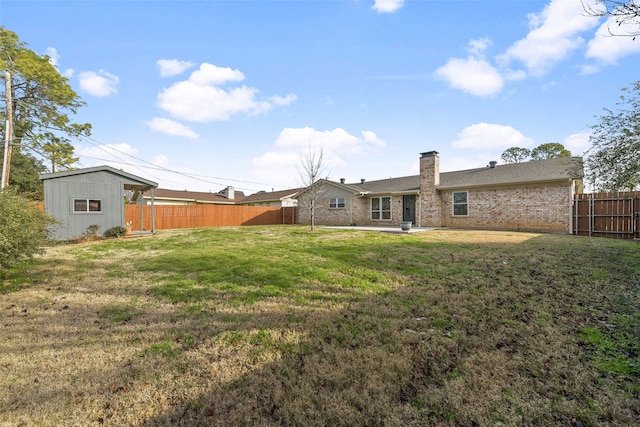 back of property featuring a patio area, an outbuilding, and a yard