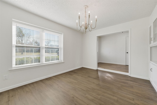 interior space with dark hardwood / wood-style flooring, an inviting chandelier, and a textured ceiling