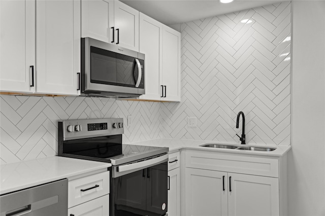 kitchen with stainless steel appliances, white cabinets, decorative backsplash, and sink