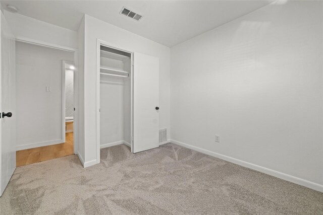 bathroom with toilet, hardwood / wood-style flooring, tiled shower, and vanity