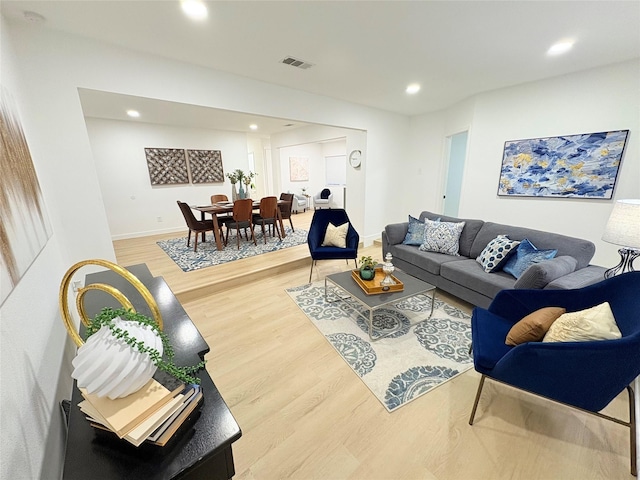 living area with recessed lighting, baseboards, visible vents, and light wood finished floors