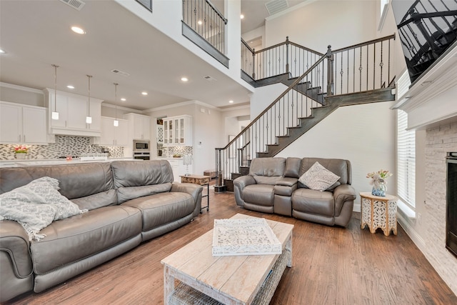 living room with a fireplace, hardwood / wood-style flooring, and crown molding