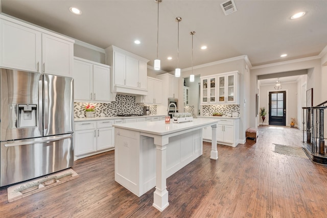 kitchen featuring white cabinets, a center island with sink, appliances with stainless steel finishes, and hanging light fixtures