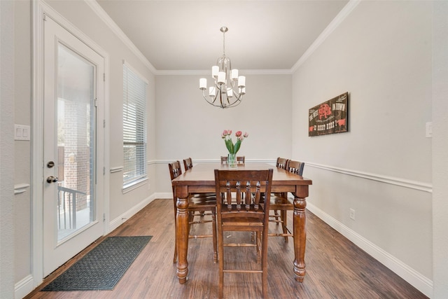 dining room with ornamental molding, dark hardwood / wood-style flooring, and a chandelier