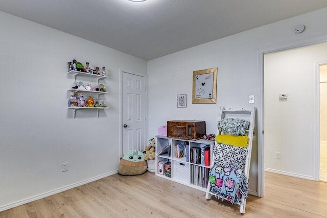 game room with light hardwood / wood-style flooring