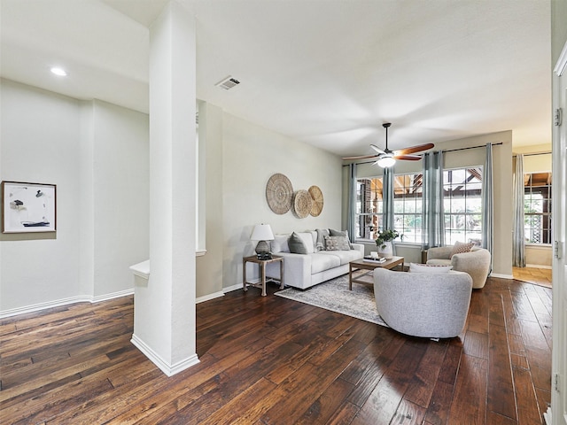 living room with ceiling fan, dark hardwood / wood-style flooring, and ornate columns