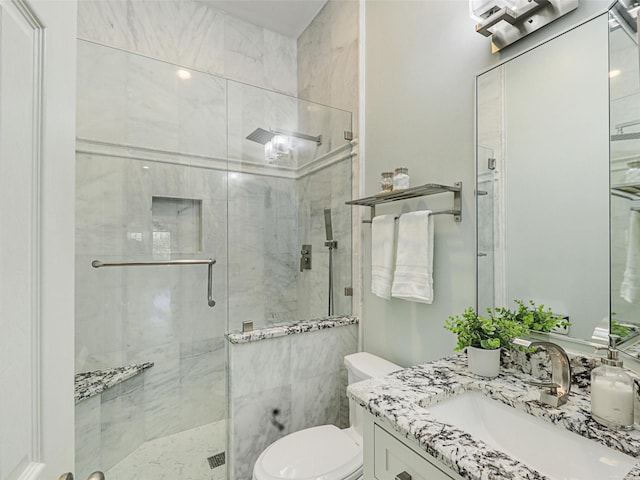 bathroom featuring toilet, a shower with door, and vanity