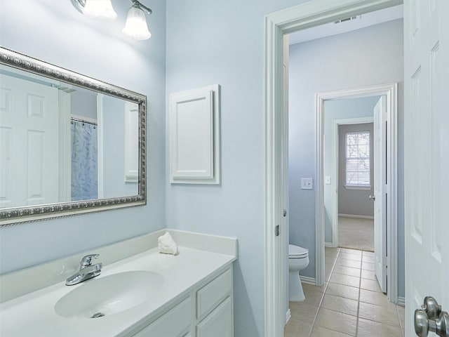 bathroom with toilet, tile patterned floors, and vanity