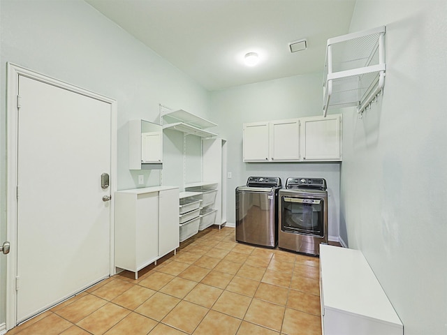 washroom featuring separate washer and dryer, cabinets, and light tile patterned floors