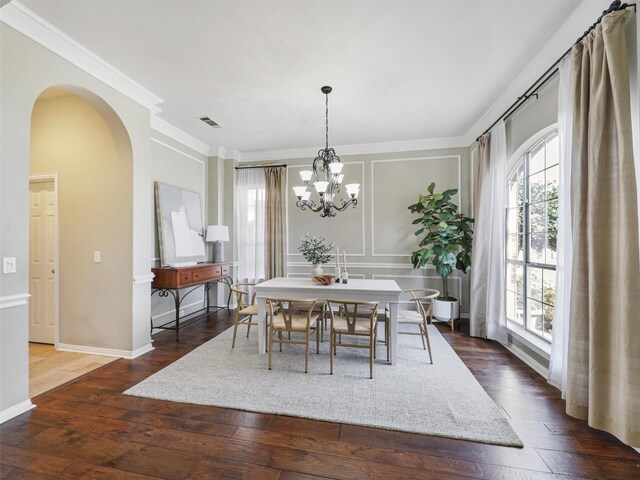 dining space with an inviting chandelier, ornamental molding, and dark hardwood / wood-style floors