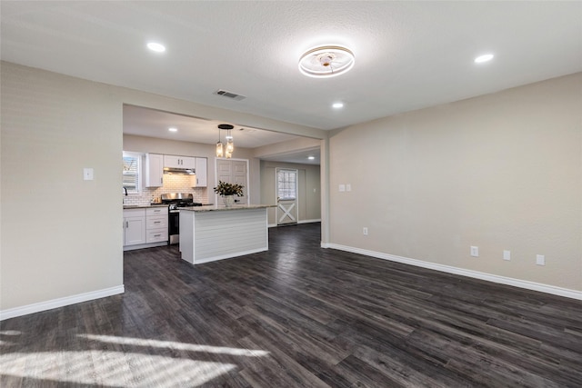 kitchen with decorative light fixtures, white cabinets, dark hardwood / wood-style floors, gas stove, and a kitchen island