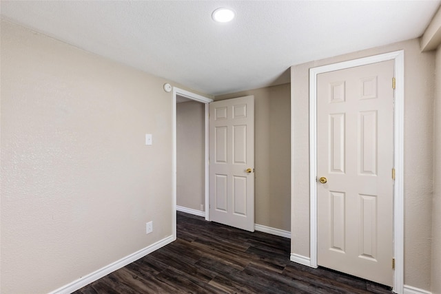 unfurnished bedroom featuring dark wood-type flooring