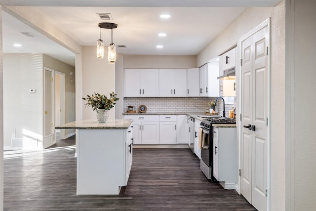 kitchen with hanging light fixtures, tasteful backsplash, a kitchen island, white cabinets, and stainless steel range with gas stovetop