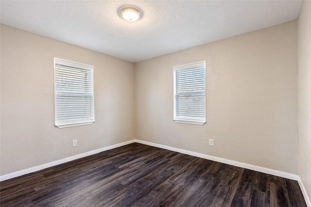 unfurnished room featuring dark wood-type flooring and plenty of natural light