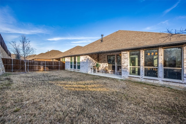 back of property featuring a patio area and a lawn