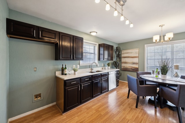 kitchen with a chandelier, hanging light fixtures, light wood-type flooring, sink, and stainless steel dishwasher