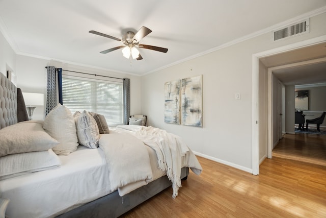 bedroom with ceiling fan, ornamental molding, and wood-type flooring