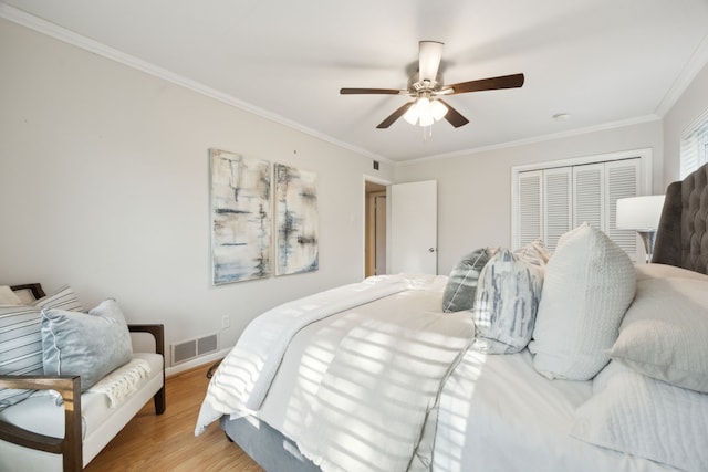 bedroom featuring a closet, ceiling fan, light hardwood / wood-style floors, and ornamental molding