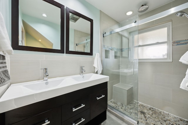 bathroom featuring vanity, walk in shower, and tile walls