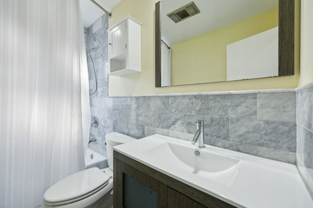 full bathroom with tile walls, shower / bath combo with shower curtain, vanity, and toilet