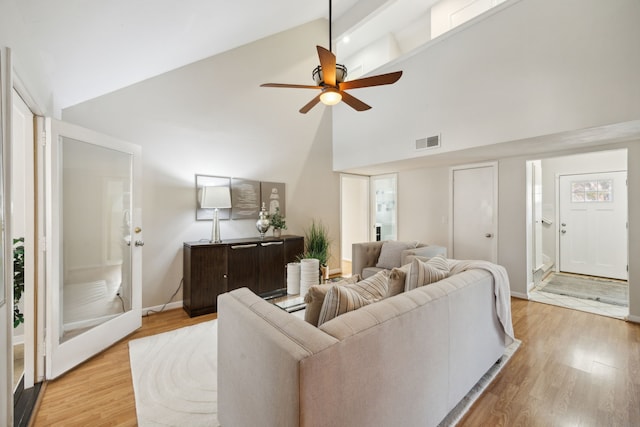 living room featuring ceiling fan, light wood-type flooring, and high vaulted ceiling