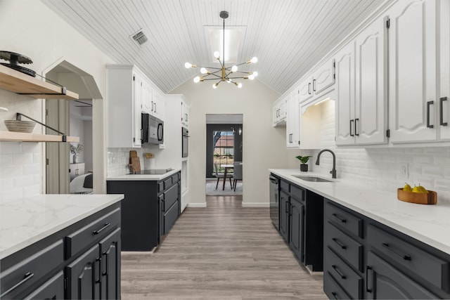 kitchen featuring white cabinets, decorative backsplash, black appliances, and sink