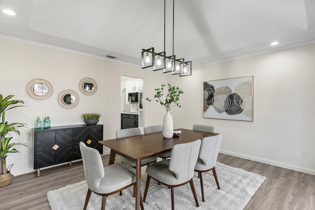 dining room with light wood-type flooring and ornamental molding