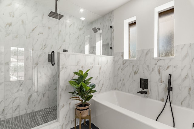 bathroom featuring tile walls and independent shower and bath