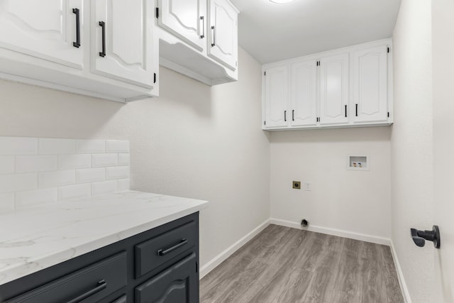 laundry room featuring electric dryer hookup, washer hookup, light wood-type flooring, and cabinets