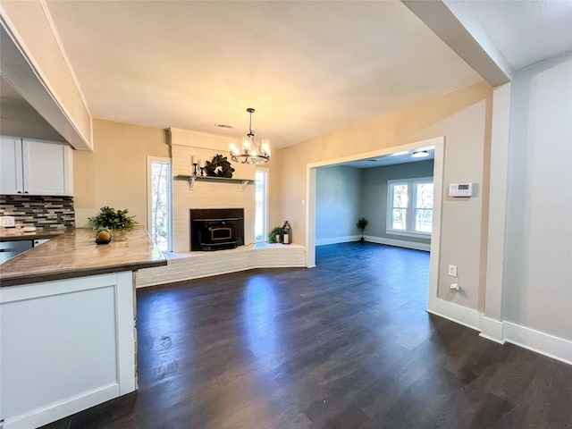 unfurnished living room with dark hardwood / wood-style flooring and an inviting chandelier