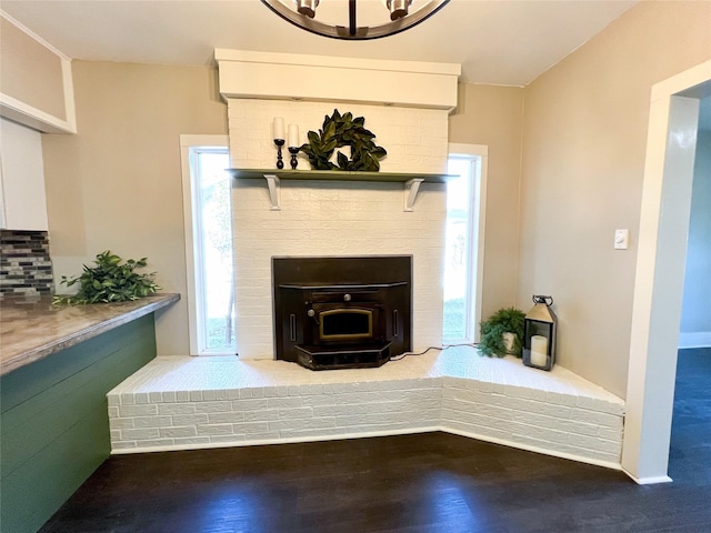 interior space with backsplash, a wood stove, and wood-type flooring