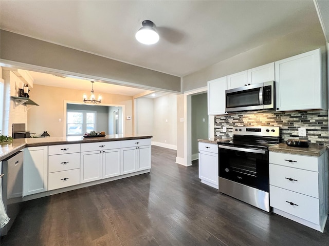 kitchen with white cabinets, stainless steel appliances, hanging light fixtures, kitchen peninsula, and a chandelier