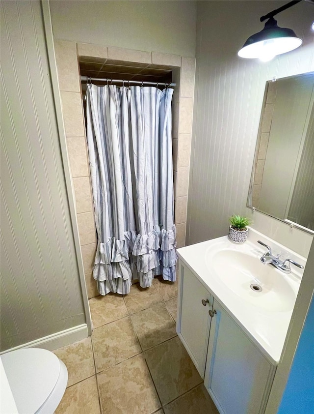 bathroom featuring toilet, tile patterned flooring, and vanity