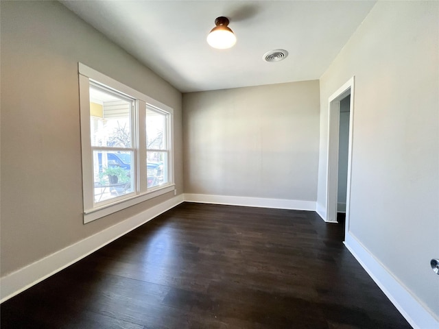 spare room with dark wood-type flooring