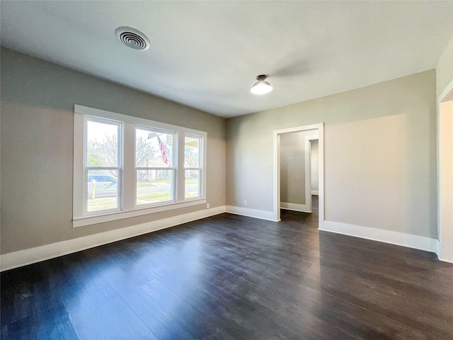 unfurnished room with dark wood-type flooring