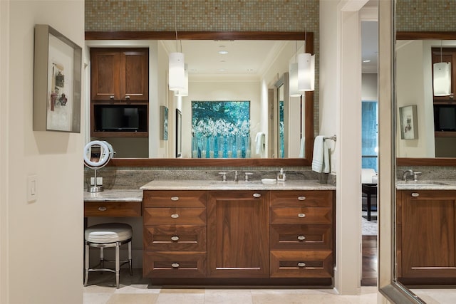 bathroom with tile patterned floors, crown molding, and vanity