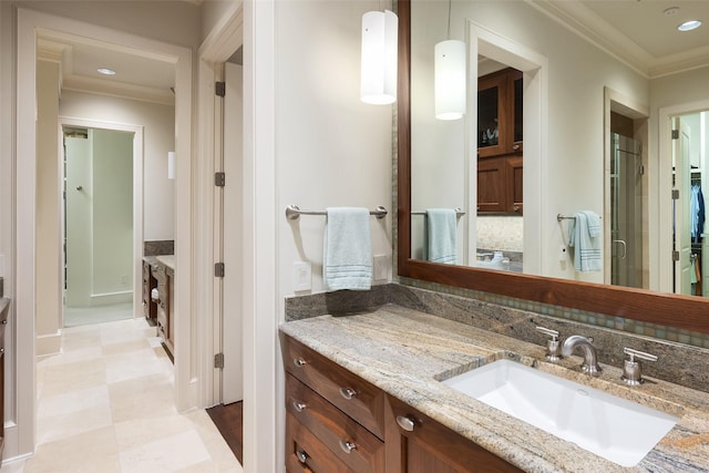 bathroom featuring an enclosed shower, vanity, and ornamental molding